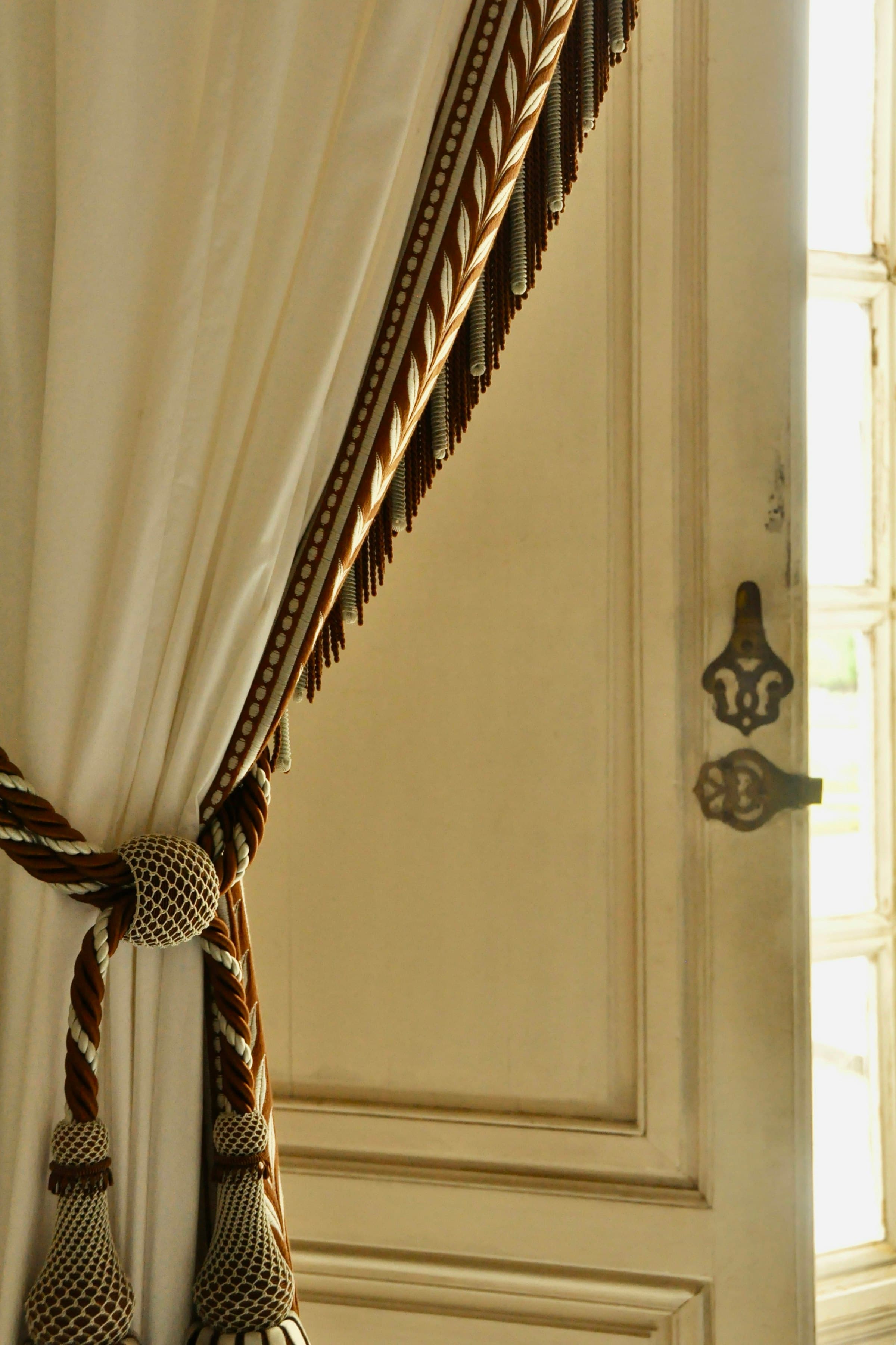 Cream curtain with a braided tie-back