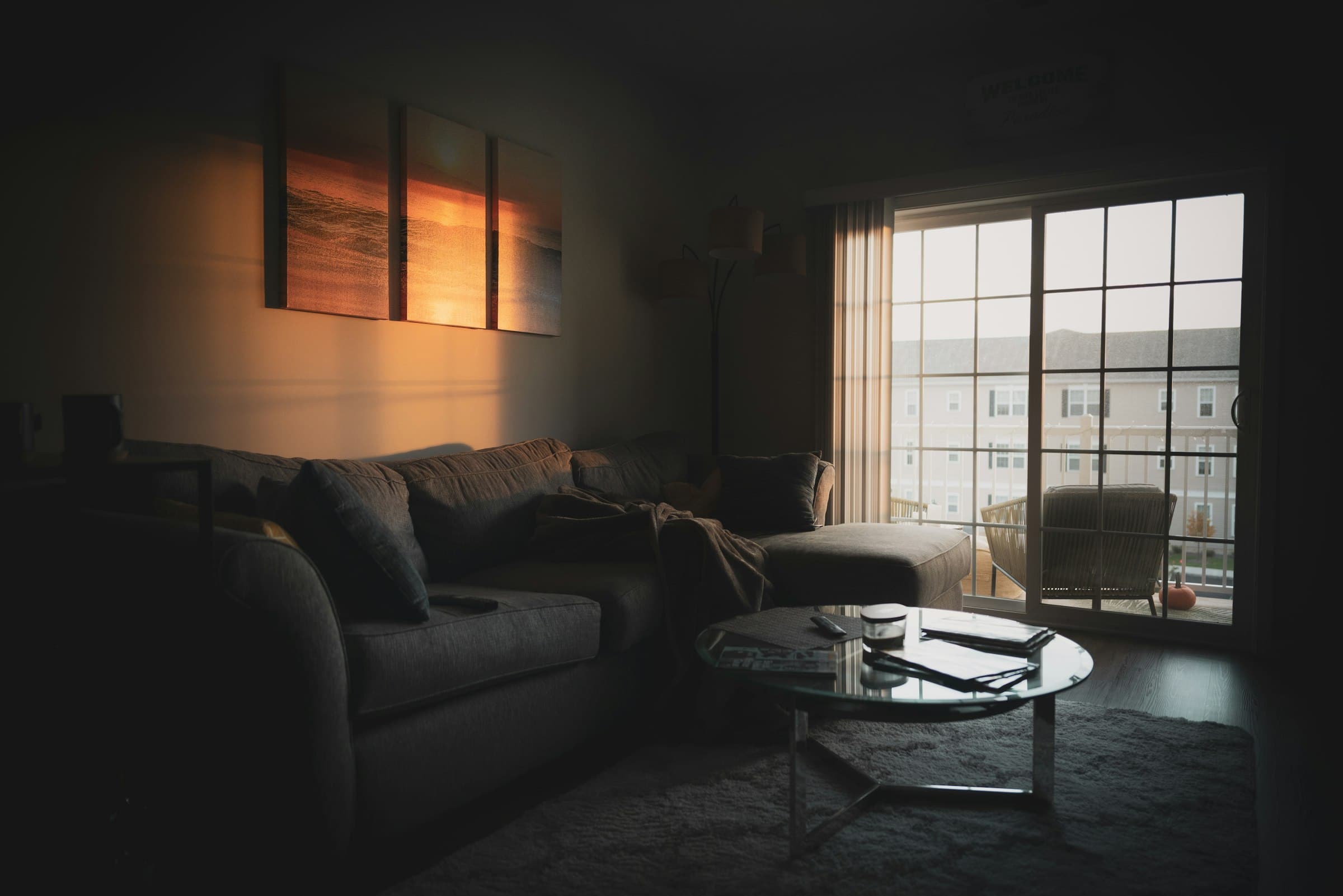 Living room at dusk with deep sofas and evening light from tall windows