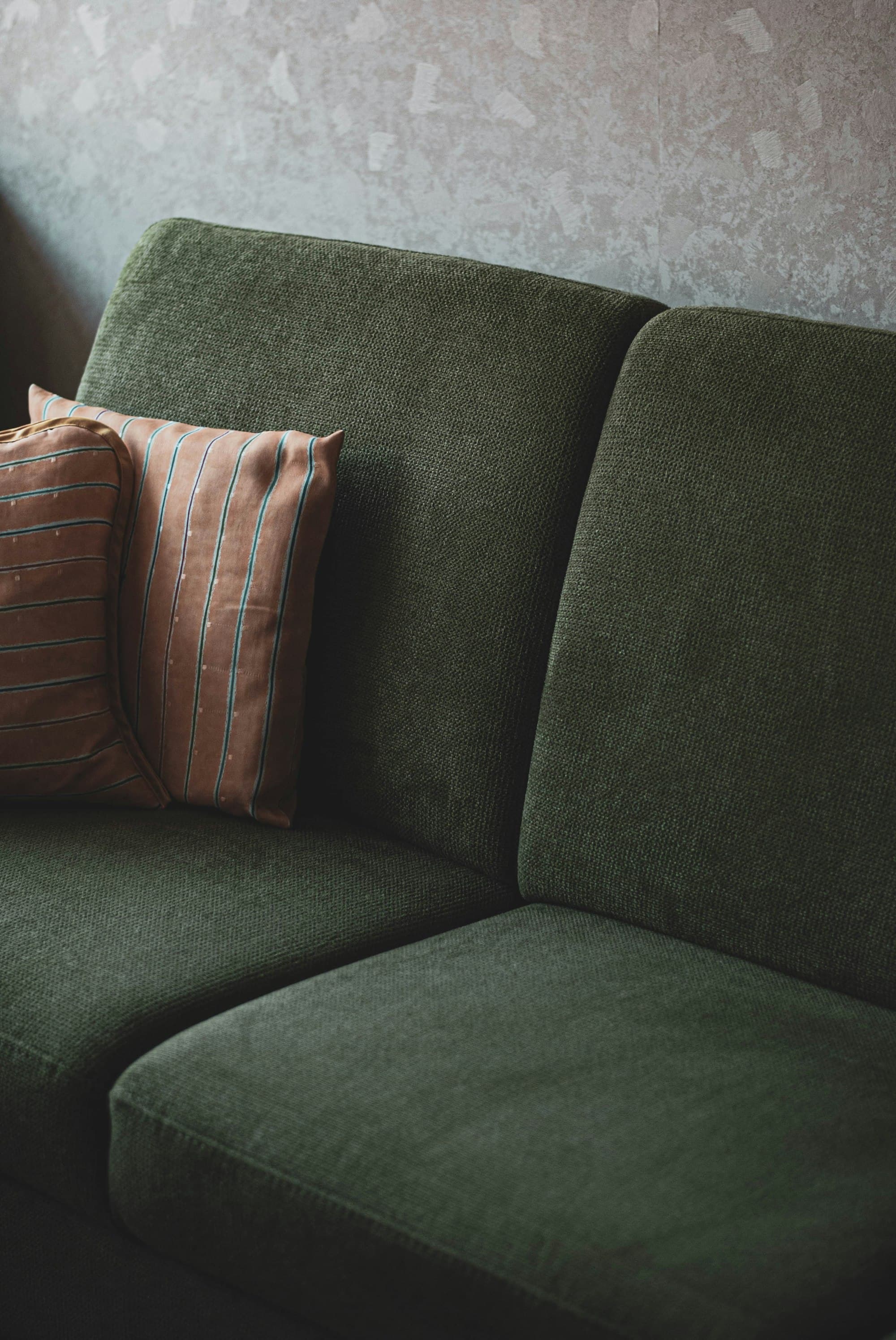 Green sofa with soft striped cushions